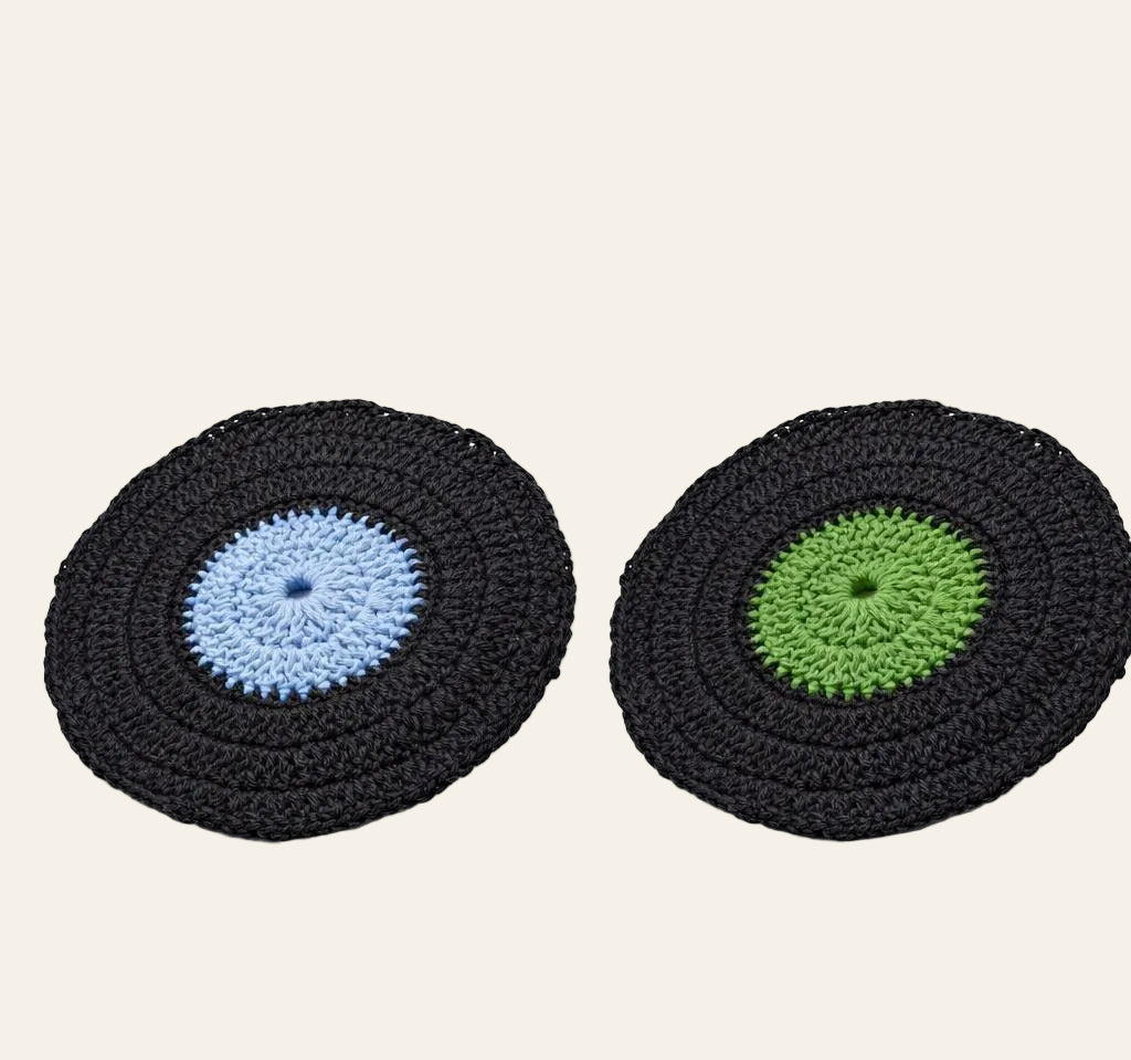 Vinyl record crochet coaster placed beside an actual record player showing the realistic record look
