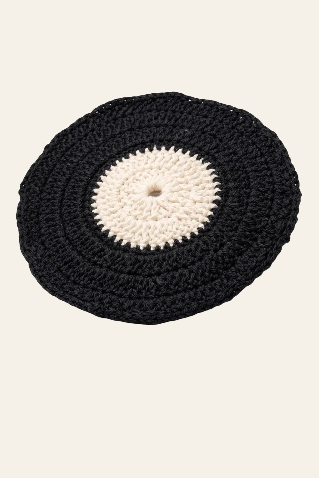 Vinyl record crochet coaster pattern — handmade black coaster with contrasting label center under a coffee mug